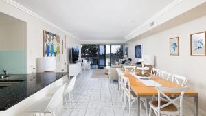 a dining room with a table and white chairs at On the Beach Getaway in One Mile