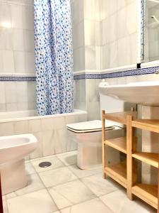 a white bathroom with a toilet and a sink at Acogedor Apartamento en Sierra Nevada in Sierra Nevada