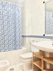 a bathroom with a toilet sink and a shower curtain at Acogedor Apartamento en Sierra Nevada in Sierra Nevada