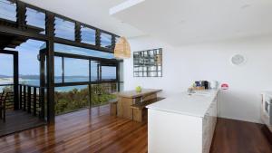 a kitchen with white countertops and large windows at One Mile Retreat in Anna Bay