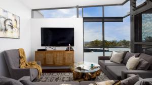a living room with a tv and a couch and a table at One Mile Retreat in Anna Bay