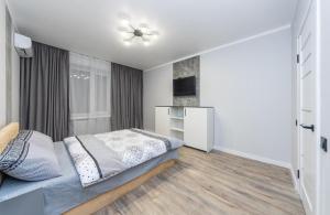 キーウにあるAparts Lesi Ukrainki 24の白いベッドルーム(ベッド1台、テレビ付)