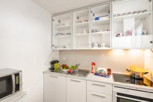 a kitchen with white cabinets and a sink and a microwave at Villa Delle Rose - Happy Rentals in Arogno