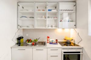 a kitchen with white cabinets and a sink at Villa Delle Rose - Happy Rentals in Arogno