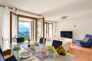 a living room with a glass table and a couch at Villa Delle Rose - Happy Rentals in Arogno