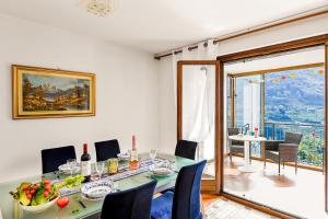 a dining room with a table and chairs at Villa Delle Rose - Happy Rentals in Arogno