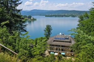 a large building on the shore of a lake at Holiday flats Seehaus Gaby Maria Wörth am Wörthersee - OKT01013-SYC in Reifnitz