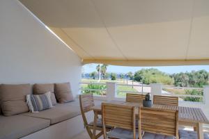 a living room with a couch and a table and chairs at Maia beach house in Rafina