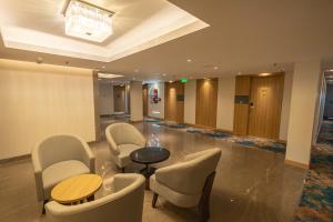 een lobby met een tafel en stoelen in een kamer bij Golden Tulip Bhopal in Bhopal