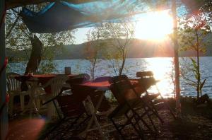 una mesa y sillas con el sol brillando sobre un lago en Sehsuvar Peace Pension, en Egirdir