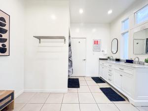 una cocina blanca con armarios blancos y fregadero en Stylish Residence in Los Angeles - OL-WH, en Los Ángeles
