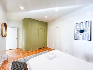a bedroom with a white bed and a green wall at Stylish Residence in Los Angeles - OL-WH in Los Angeles