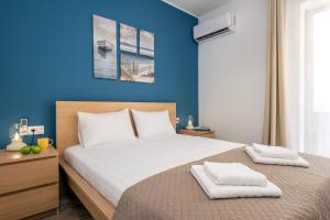 a bedroom with a large bed with blue walls at Urban Elegance - City Center 3-Bedroom Apartment in Chania