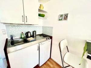 a small kitchen with a sink and a table at Cosy apartment with private terrace in Vallensbæk