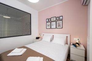 a white bedroom with a bed and a window at Urban Elegance - City Center 3-Bedroom Apartment in Chania