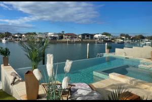 una piscina junto a un cuerpo de agua en Bella Vista Bed and Breakfast of Raby Bay en Cleveland