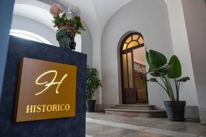 a sign in the lobby of a building with plants at Historico Loft & Rooms Palazzo Adragna XIX in Trapani