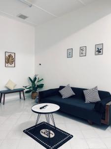 - un salon avec un canapé bleu et une table dans l'établissement Comfort Semi D House, 1 min to Town by Mr Homestay, à Teluk Intan