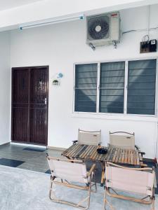 un patio con 2 sedie, un tavolo e un ventilatore di Comfort Semi D House, 1 min to Town by Mr Homestay a Teluk Intan