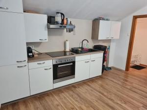 a kitchen with white appliances and a wooden floor at StayEasy Apartments Ramingtal #1 