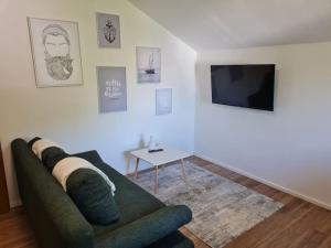 a living room with a green couch and a table at StayEasy Apartments Ramingtal #1 