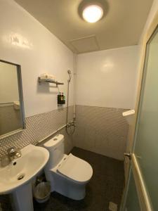 a bathroom with a white toilet and a sink at The Cozy House in Kenting