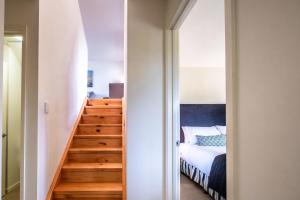 una camera da letto con una scala che conduce a un letto di Hamptons Hideaway - Freycinet Holiday Houses a Coles Bay