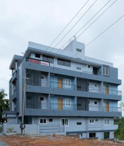 a gray building with a lot of windows at Rashra Residency in Manipala