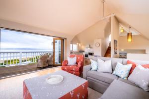 un soggiorno con un divano e un tavolo di Hamptons Hideaway - Freycinet Holiday Houses a Coles Bay