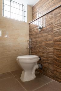 a bathroom with a white toilet in a room at Rashra Residency in Manipala