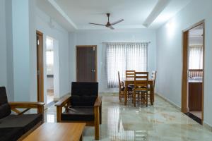 uma sala de estar com mesa e cadeiras em Rashra Residency em Manipal