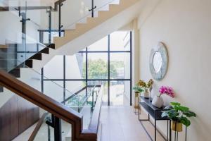 a staircase in a house with a glass stair case at Sans Hotel Box Mansion Surabaya by RedDoorz in Wonokitri 2
