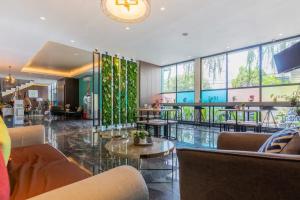 a lobby with couches and tables in a building at Sans Hotel Box Mansion Surabaya by RedDoorz in Wonokitri 2