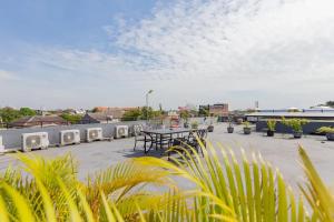 a patio with a table and chairs and plants at Sans Hotel Box Mansion Surabaya by RedDoorz in Wonokitri 2
