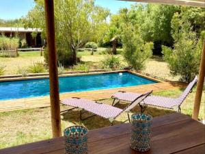 una mesa con 2 sillas y una piscina en Karoo Feels en Prince Albert