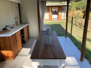 a wooden table with a vase sitting on a patio at Karoo Feels in Prince Albert