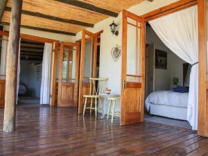 1 dormitorio con 1 cama y suelo de madera en Karoo Feels, en Prince Albert