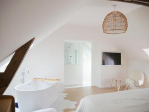 a white bathroom with a tub and a sink at Gîte Il était une fois in Bourgbarré