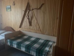 a bedroom with a bed and a wooden wall at Садиба Зґарда in Yaremche