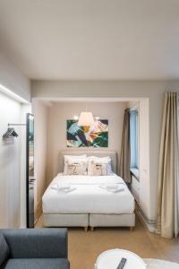 a bedroom with a white bed and a blue couch at Japie rooms - in the heart of Antwerp in Antwerp