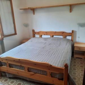 a bedroom with a wooden bed in a room at Rilassati al Corno alle Scale in Vidiciatico