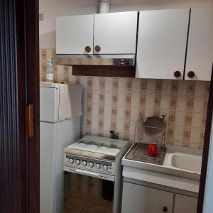 a kitchen with a stove and a white refrigerator at Rilassati al Corno alle Scale in Vidiciatico