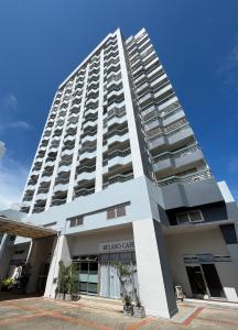 un edificio blanco alto con un letrero. en Mike's Condo en Si Racha