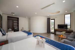 Nam Thu Hotel في كوي نون: غرفة نوم بسرير كبير وغرفة معيشة