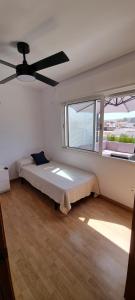 een slaapkamer met een bed en een plafondventilator bij MAGNÍFICO ÁTICO EN EL CENTRO DE DENIA in Denia
