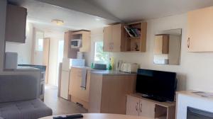 a living room with a kitchen with a tv in it at The Beeches in Lincolnshire