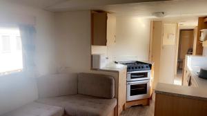 a small kitchen with a couch and a stove at The Beeches in Lincolnshire