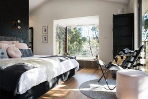 ein Schlafzimmer mit einem großen Bett und einem Fenster in der Unterkunft Daruma Hepburn - Daylesford Region in Hepburn Springs