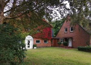 a red brick house with a white door at Ferienwohnung Benedict in Klein Rheide