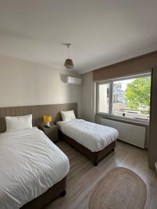 a hotel room with two beds and a window at Well Hotel Edirne in Edirne
